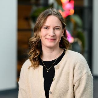 a woman in a white cardigan smiling for the camera